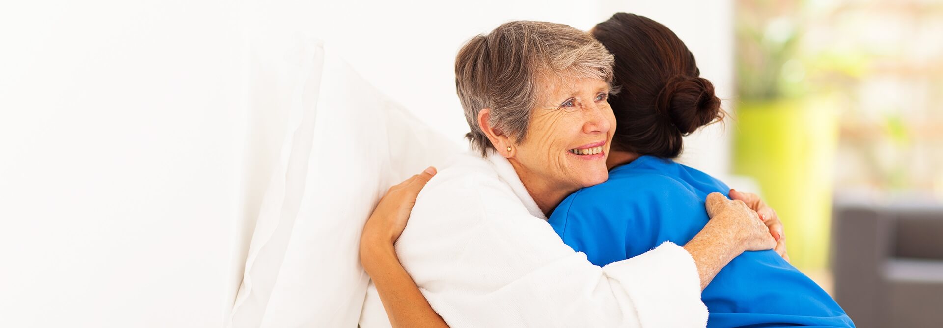 Two older people hugging each other.