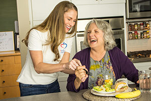 1Heart caregiver providing meal assistance to senior