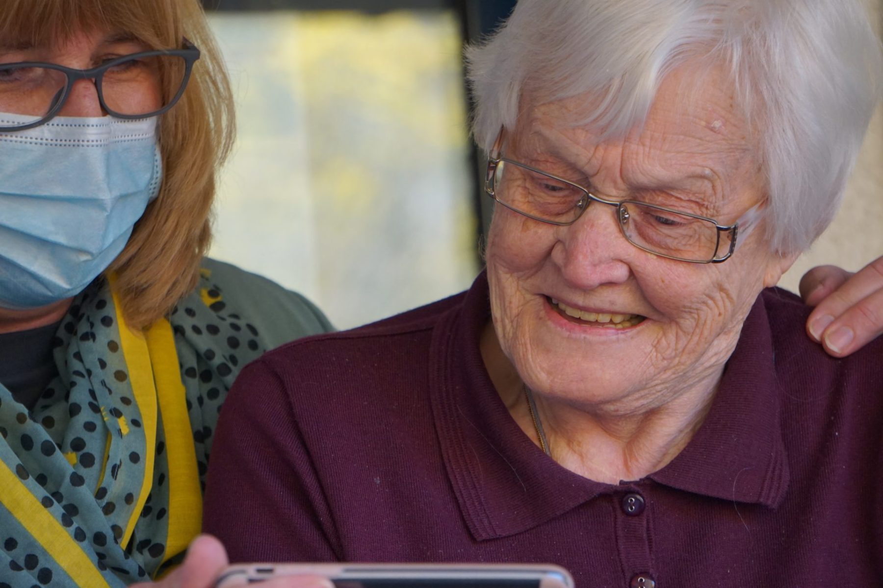  woman showing phone to older woman
