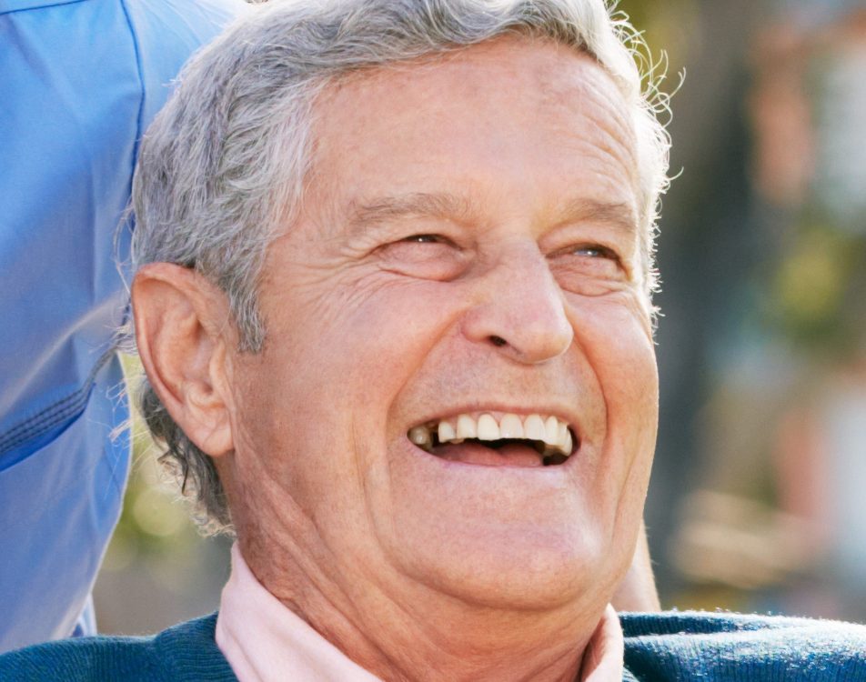 A senior man laughing with his mouth open.