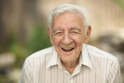 A senior man smiling at the camera.
