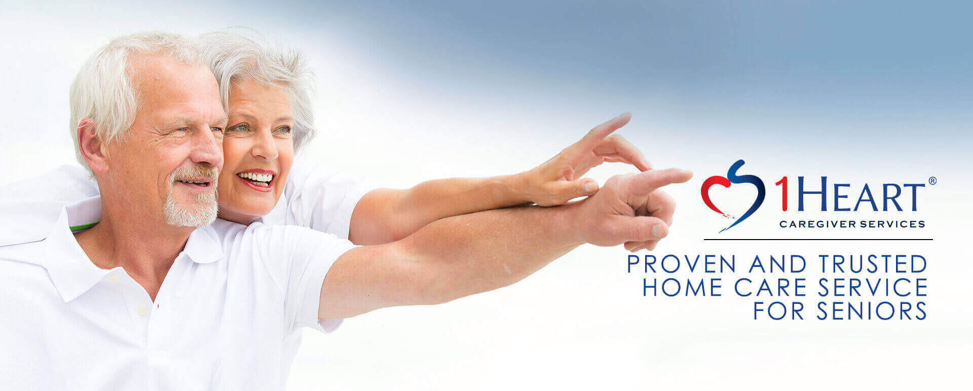 Two seniors in white pointing with 1 Heart Caregiver Services logo 'Proven and Trusted Home Care Services For Seniors'