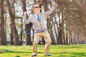 Elderly male exercising with hula hoop
