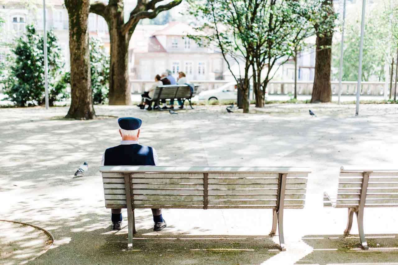 elderly man sitting on park bench