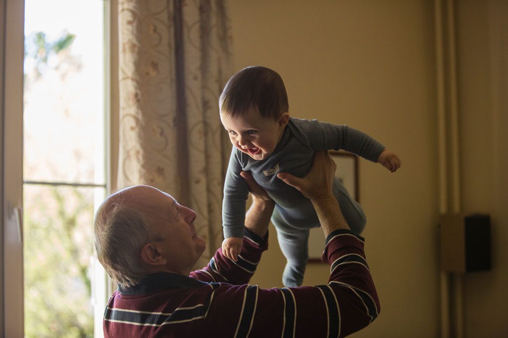 elderly man playing with baby