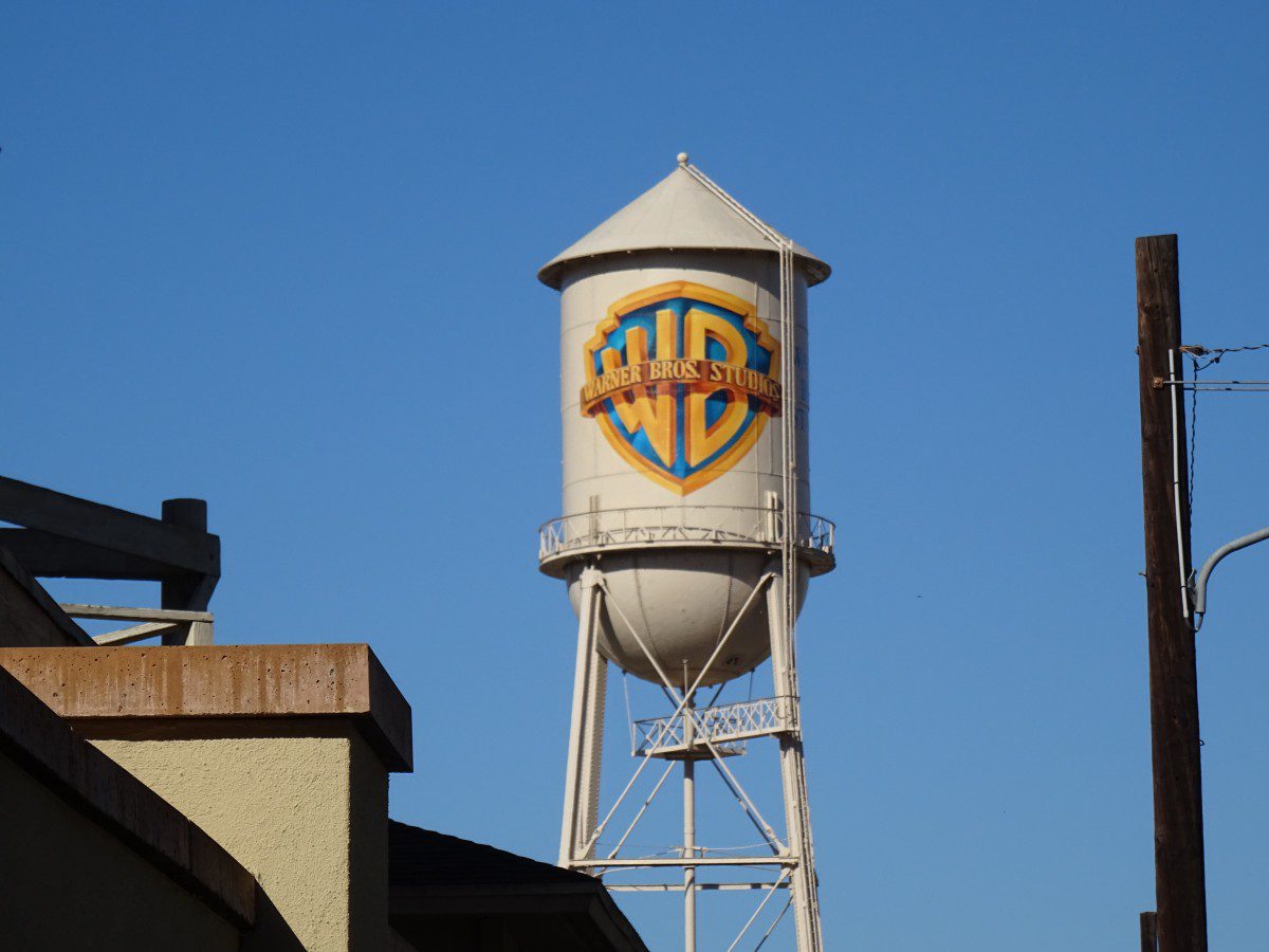 A white water tower with the Warner Brothers Studios logo.