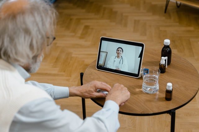 doctor providing telemedicine for elderly patient