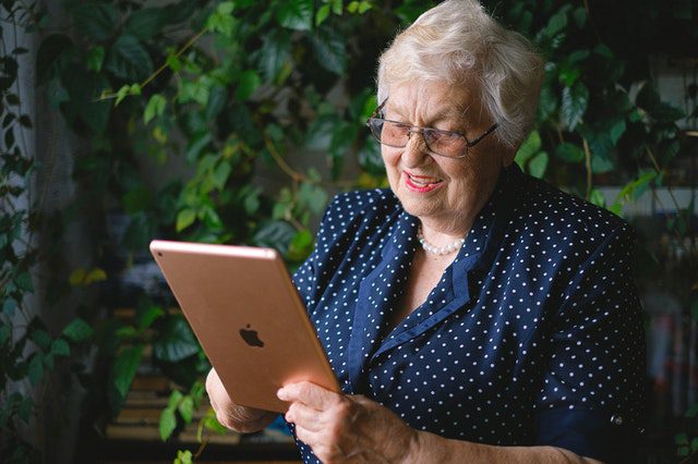 elderly lady accessing telehealth for seniors on tablet