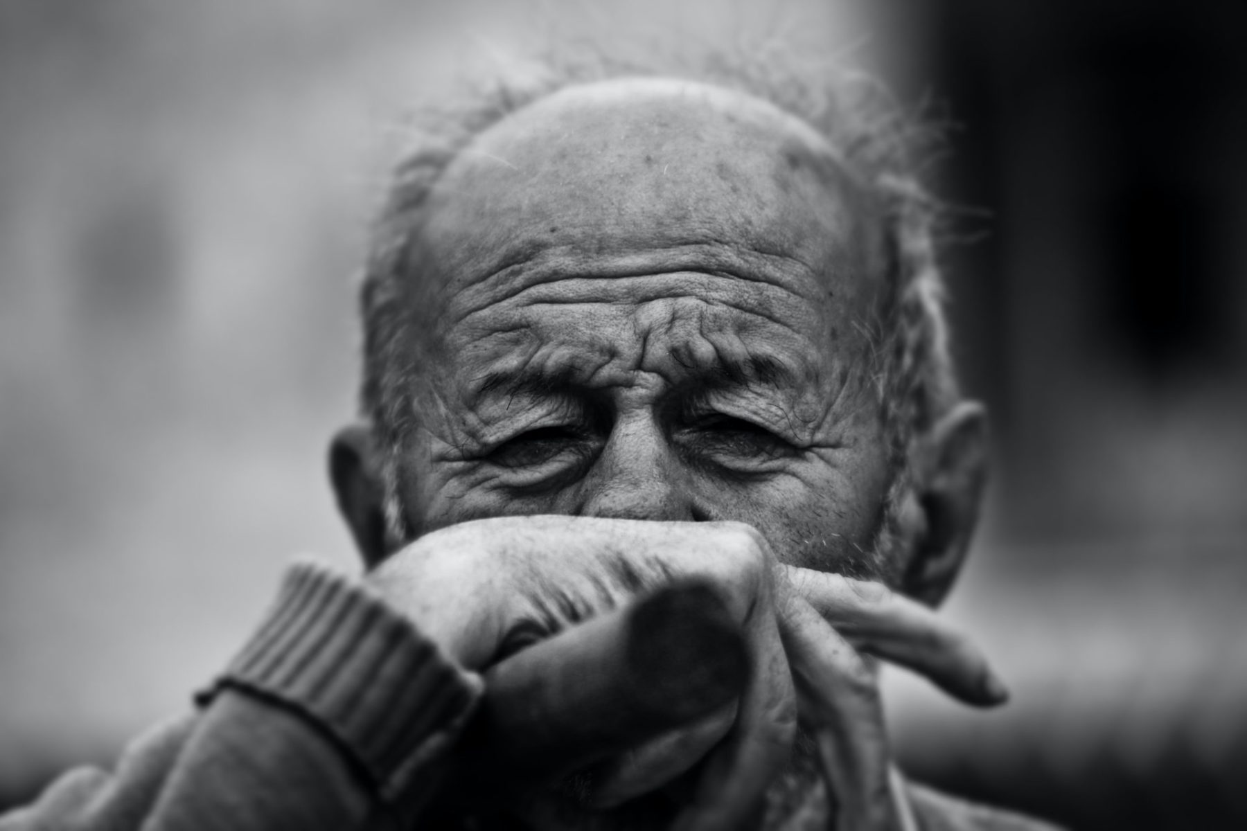 senior man covering his face with his hand