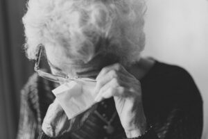 senior woman crying drying her eyes with tissue