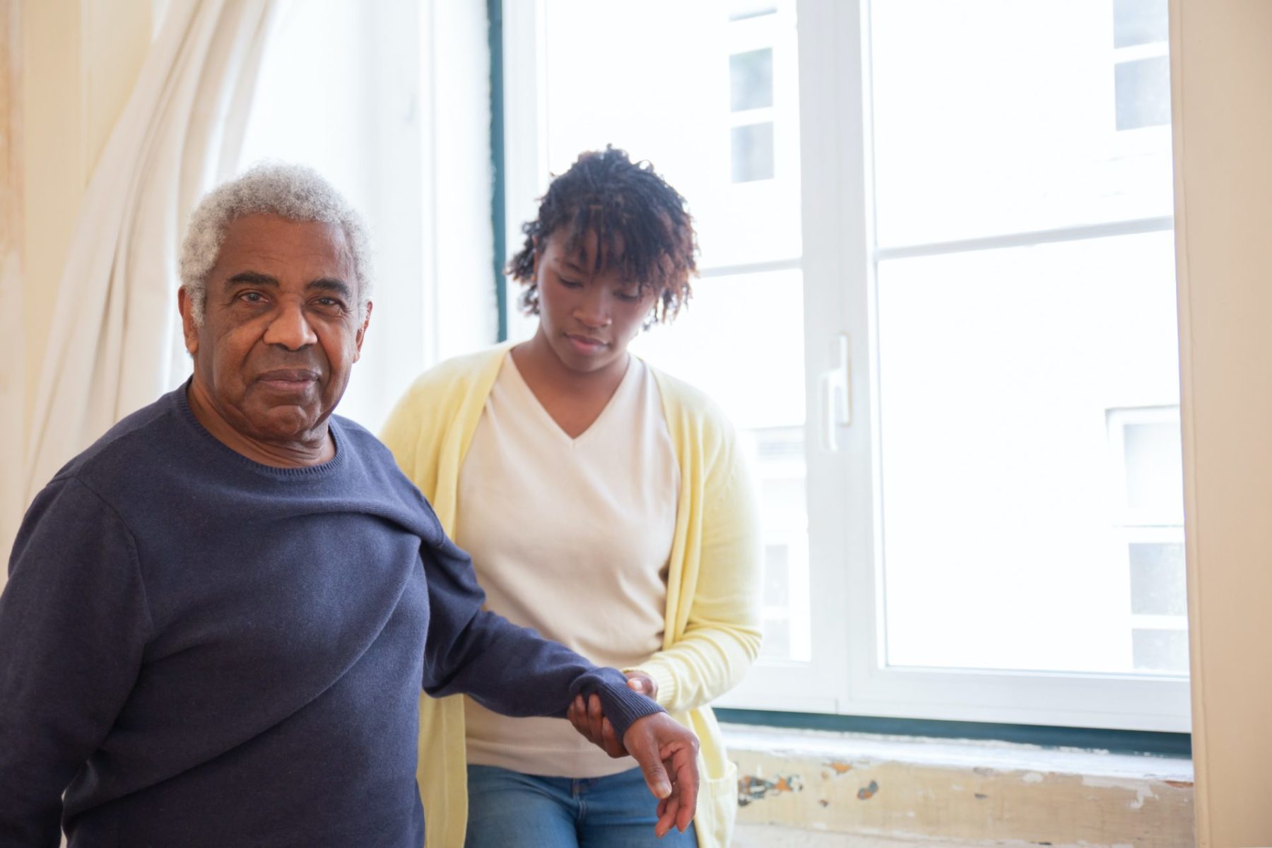 senior and caregiver performing range-of-motion exercises
