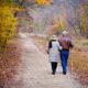 Elderly couple walking on a trail in fall