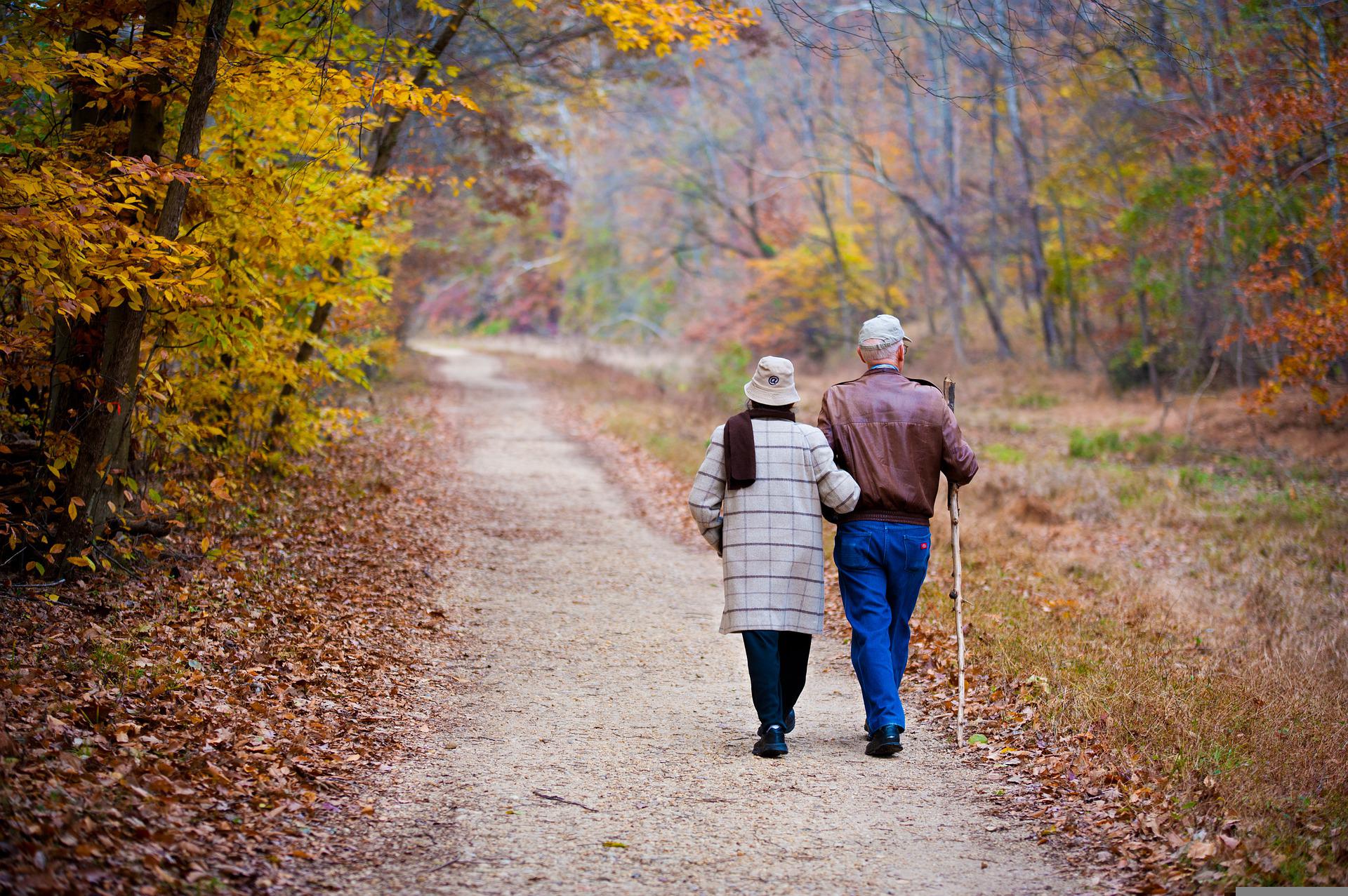 Elderly couple walking on a trail in fall