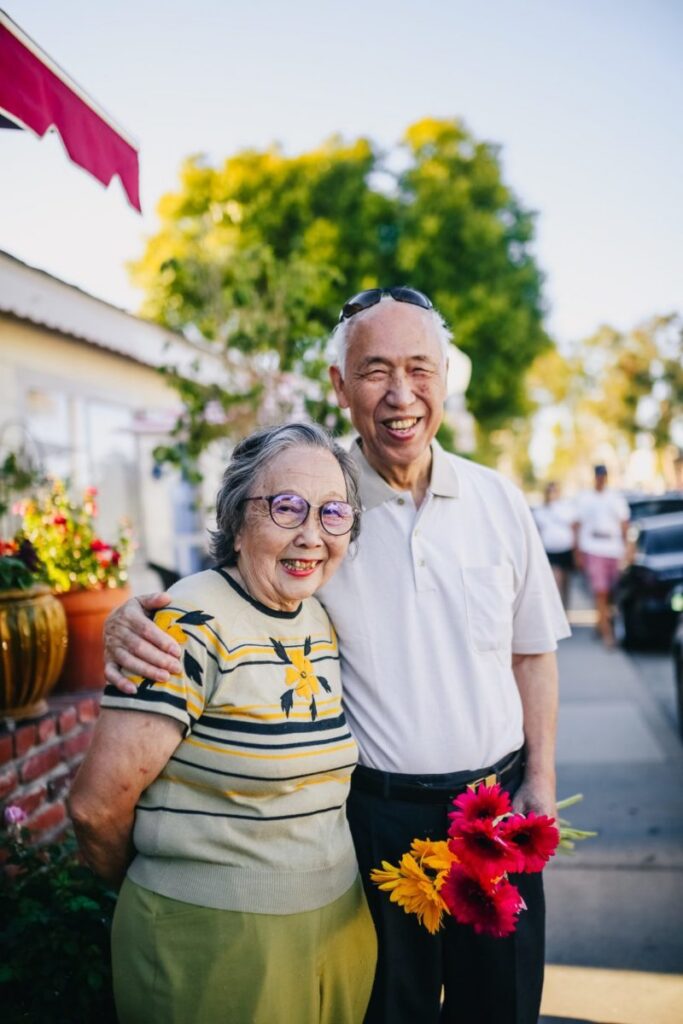 A senior couple visits a summer outdoor market.