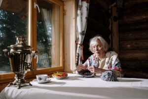 Grandmother knitting by the cabin window