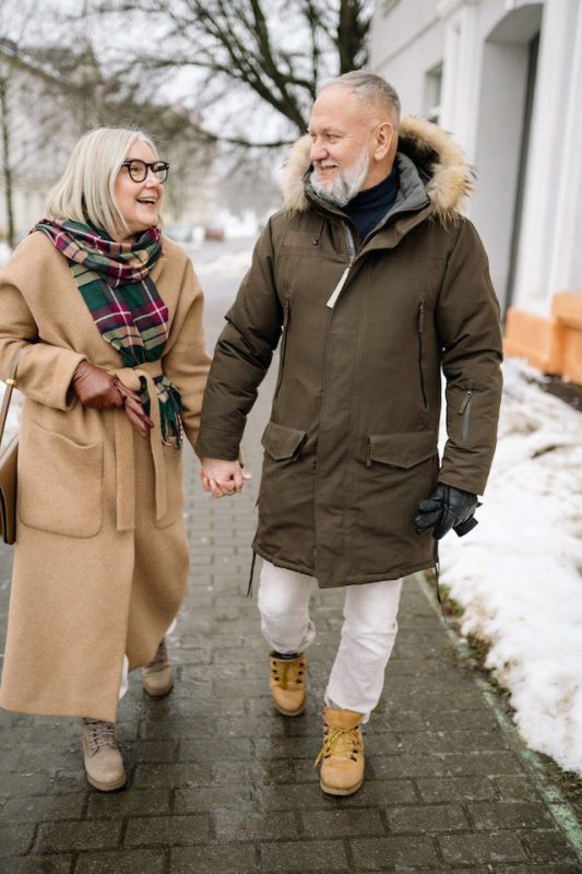 Two seniors walking outdoors in the winter.