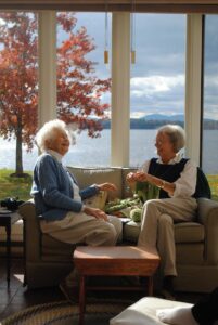 Two seniors knitting on a winter day.