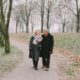Two seniors walk in a park during winter.