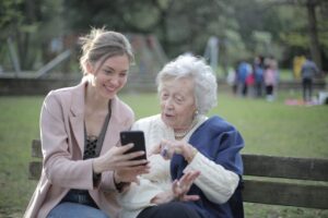 Senior woman and professional companion looking at photos on an iPhone.
