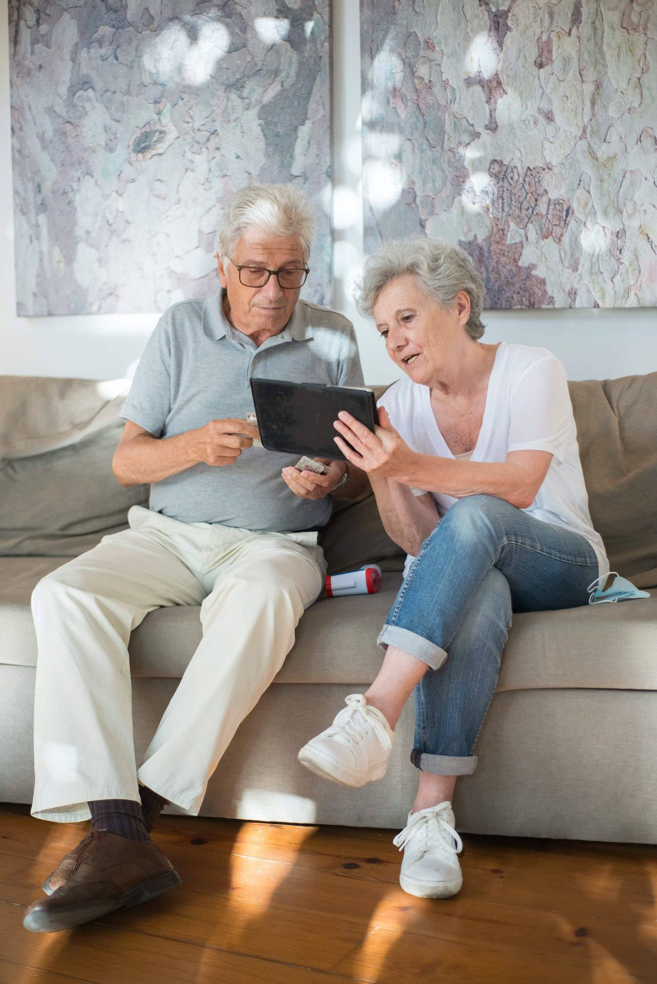 An elderly couple review care services on a tablet computer. 
