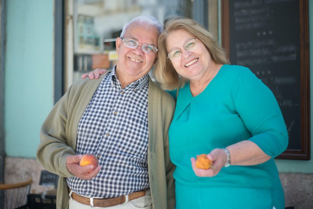 An older man and a caregiver stand in front of a grocery store