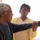 A caregiver helps an elderly client with rehab exercises after surgery.