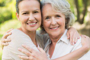 A 1Heart Caregiver Services aide with her arm around her patient