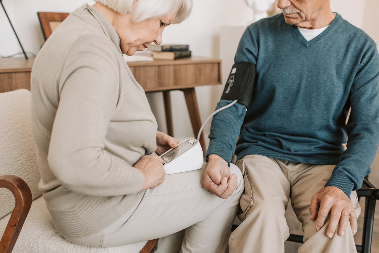 A home care nurse checks an elderly man’s blood pressure.