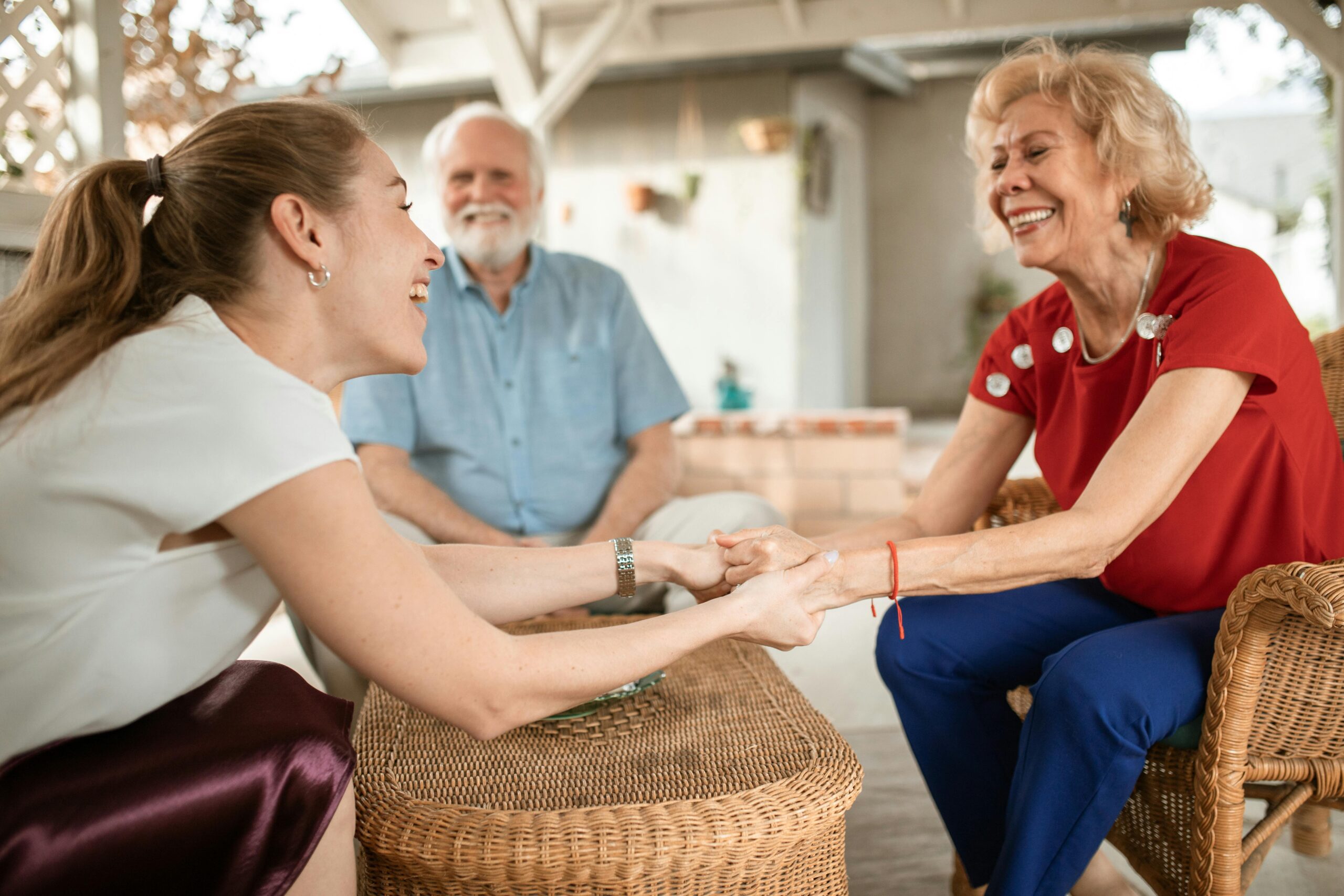 A young woman smiling and holding hands with an elderly woman