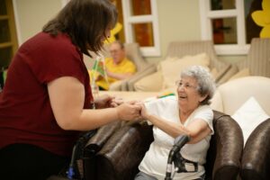 A caregiver holding hands with an elderly woman